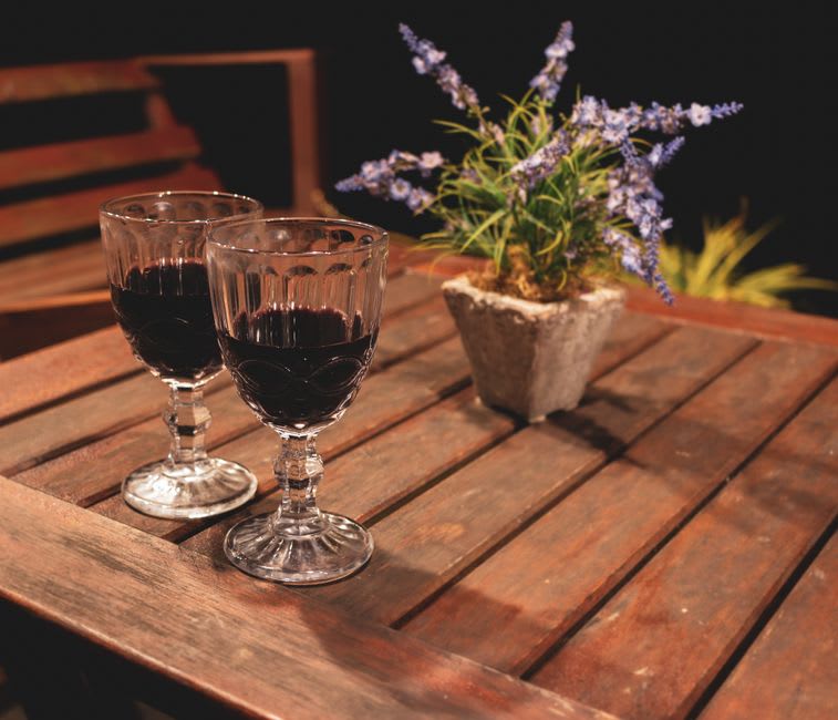 Glasses of red Dão wine on a wooden table at a small Viseu tasca, bottle and bread in the background