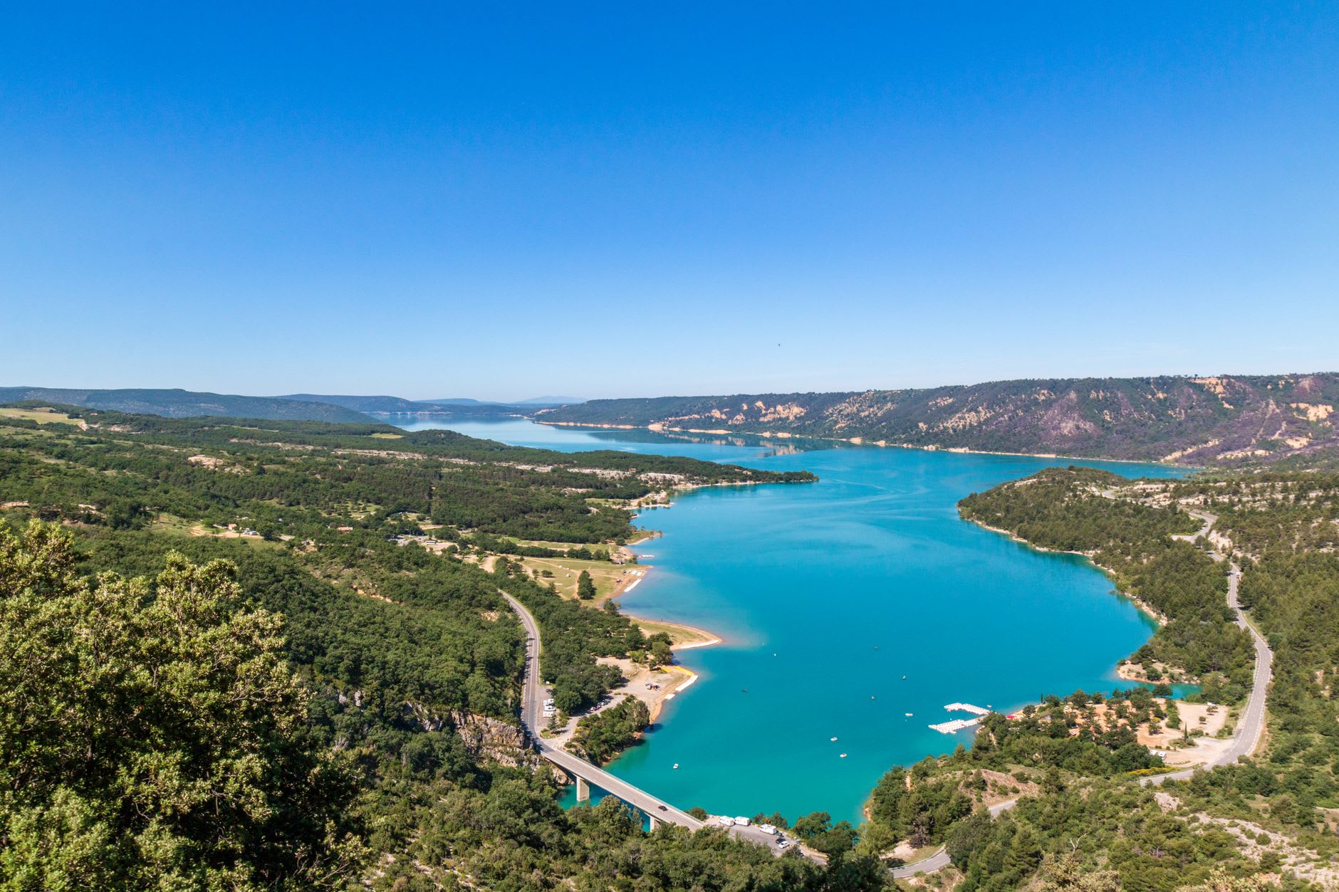 A hairpin road clinging to the cliff edge above the deep limestone canyon of the Verdon