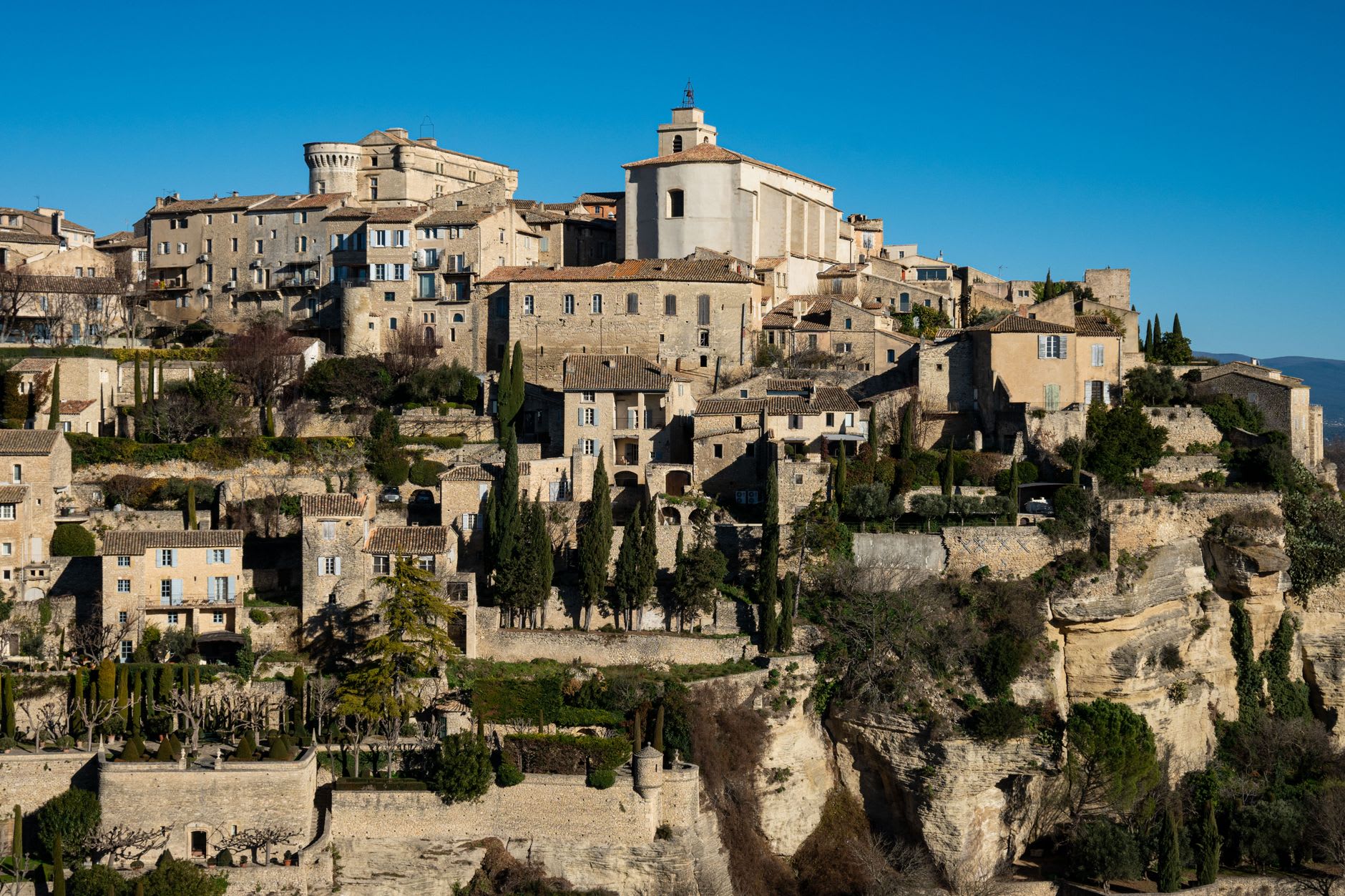 Les tours en ruine du Château des Baux contre un ciel dur et bleu des Alpilles, la plaine de la Crau visible très en contrebas