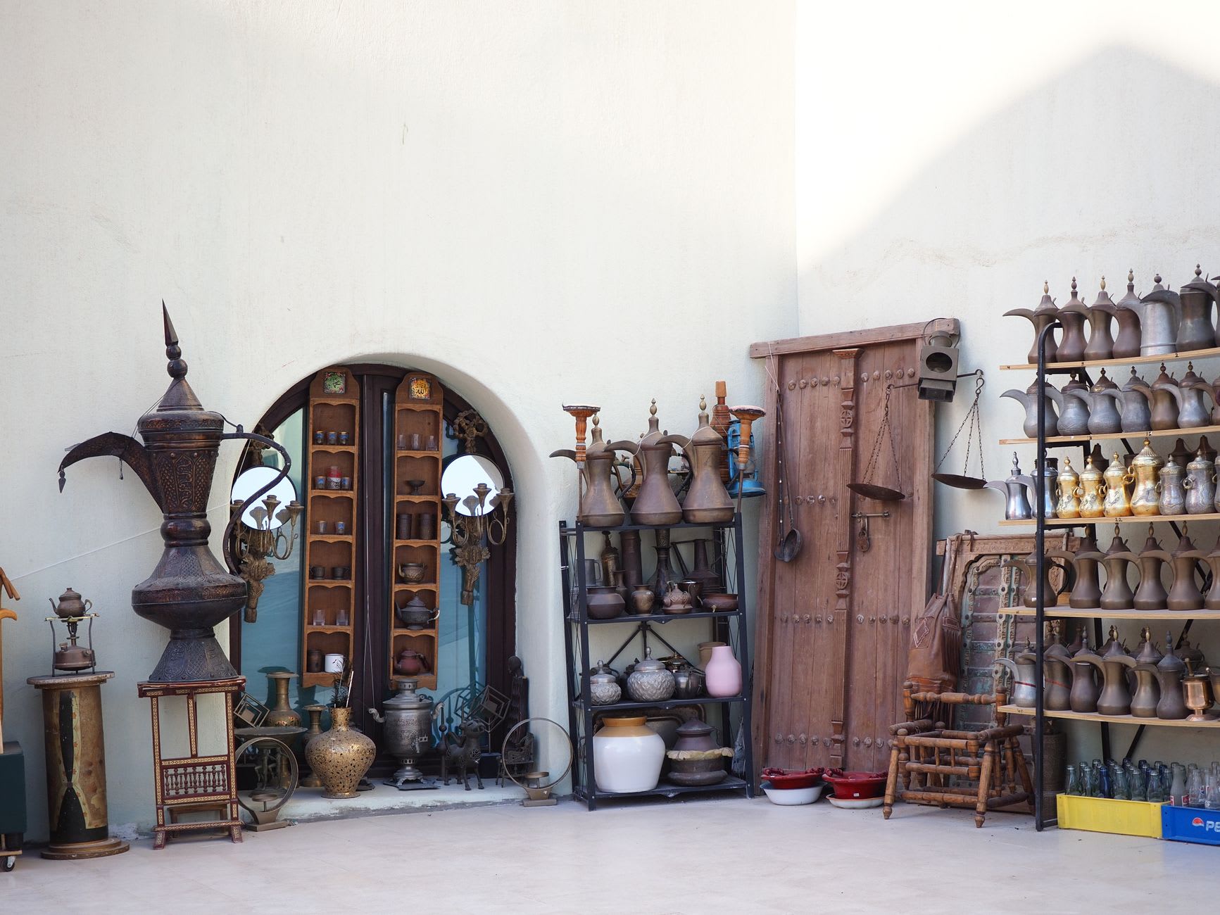 Iron lanterns casting amber light over spice displays in the covered passages of Souq Waqif