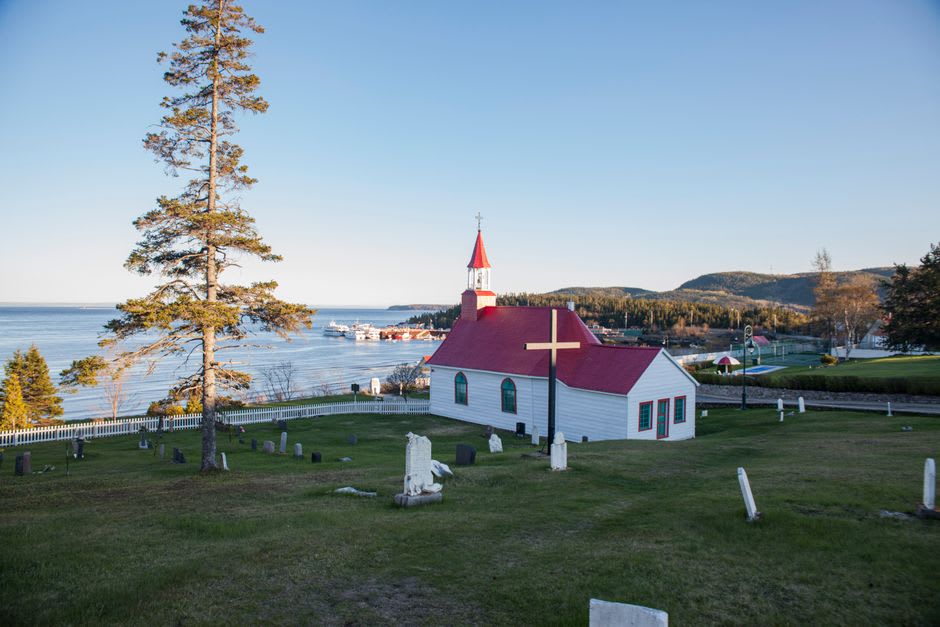 The confluence of the Saguenay fjord and the St. Lawrence River at Tadoussac, dark fjord water meeting pale estuary water