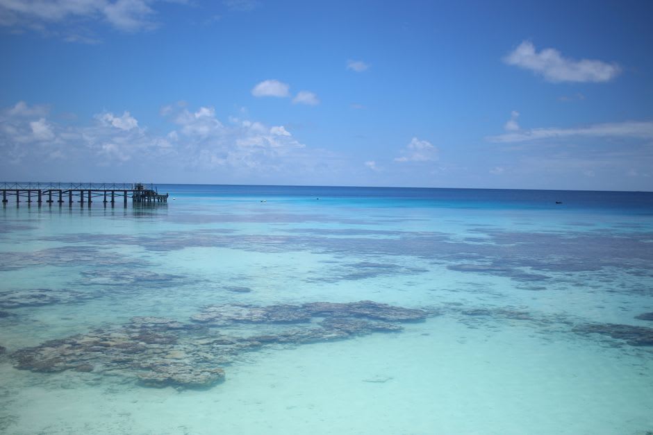 La laguna turquesa y el cayo de coral de Lady Musgrave Island visto desde el agua, con un pequeño islote de arena a lo lejos