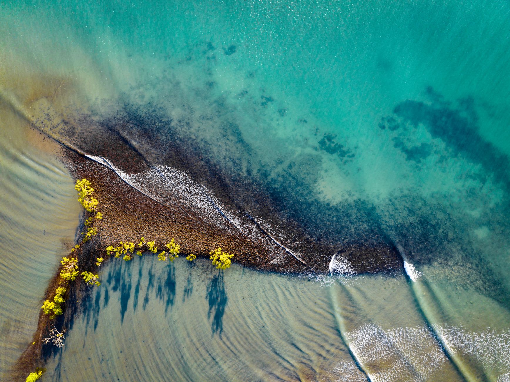 La Captain Cook Highway serpentant au bord de la falaise au-dessus de la mer de Corail à l'aube, montagnes derrière, l'eau comme de l'argent martelé dans la lumière matinale