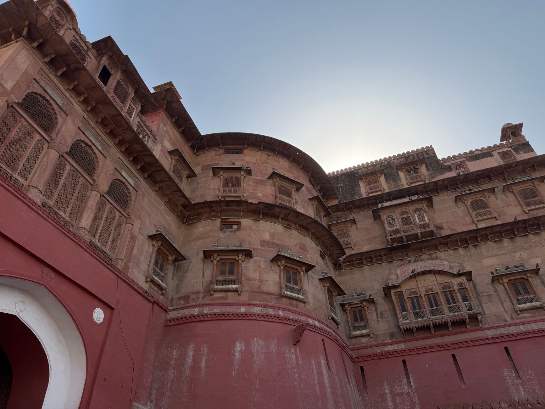 Un kachori de Bikaner en préparation dans un étal de rue — les coques de pâte dorées empilées et un vendeur versant la garniture de lentilles épicées