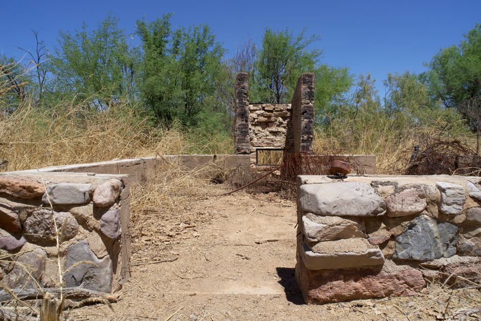 Low stone foundations of the ancient Ptolemaic temple ruins at Berenice, scattered across a flat desert site near the coast