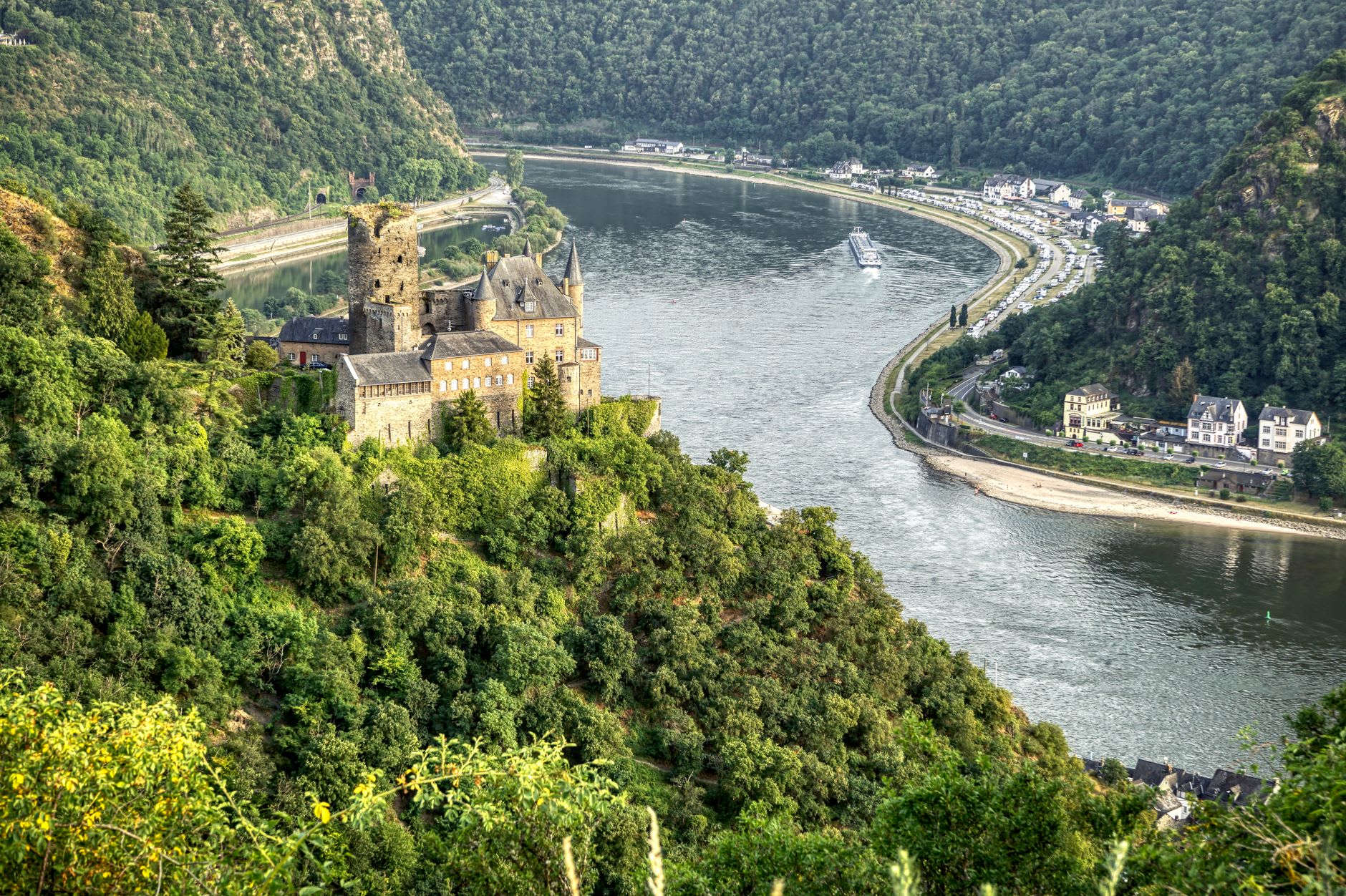 Oberwesel's medieval towers and walls reflected in the calm Rhine with Schönburg Castle on the ridge above
