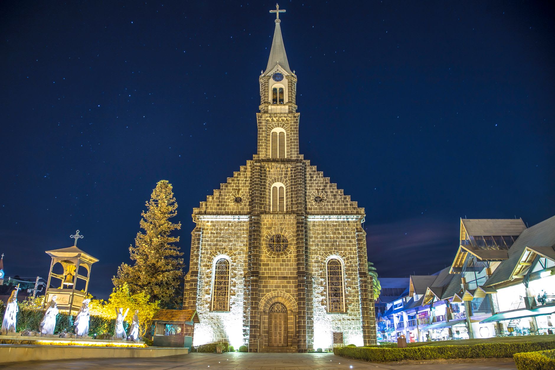 The sandstone facade of São Miguel das Missões church glowing red-orange at golden hour, swallows in flight against the warm sky