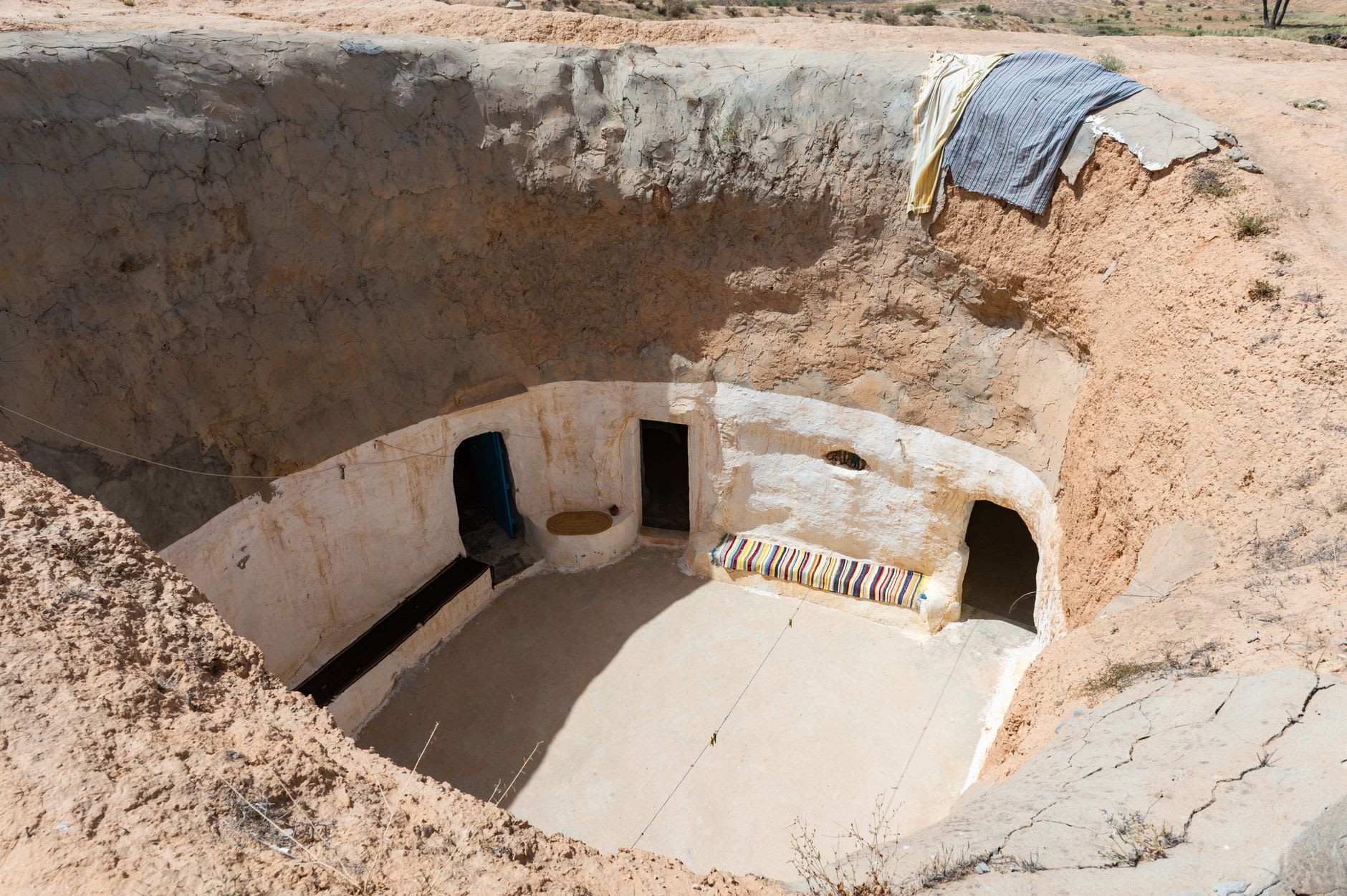 Una vivienda troglodita en Matmata, el patio circular abierto al cielo con puertas talladas bajo el nivel del suelo