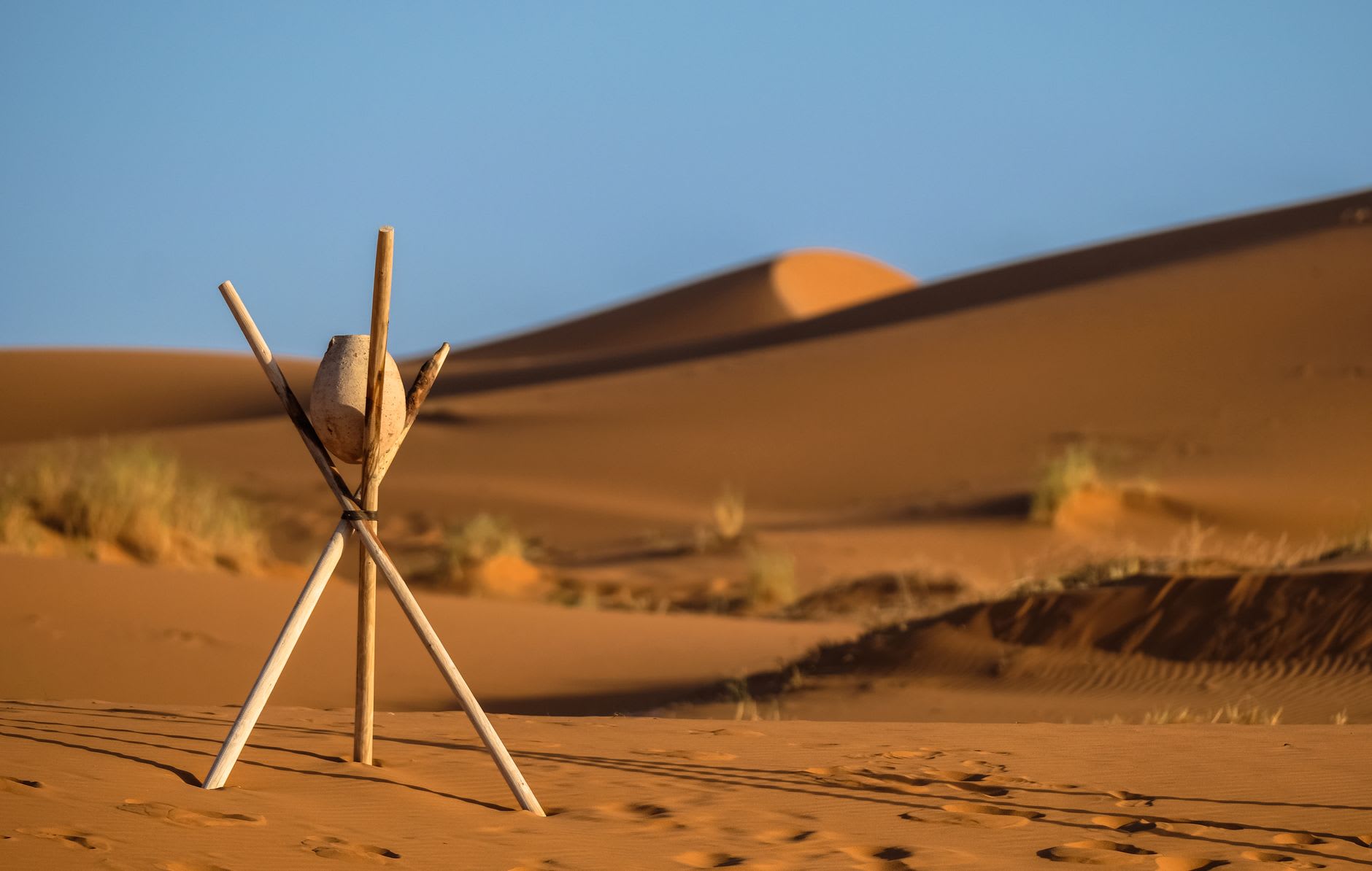 Erg Chebbi dunes at sunset, ridgelines glowing copper and shadow purple