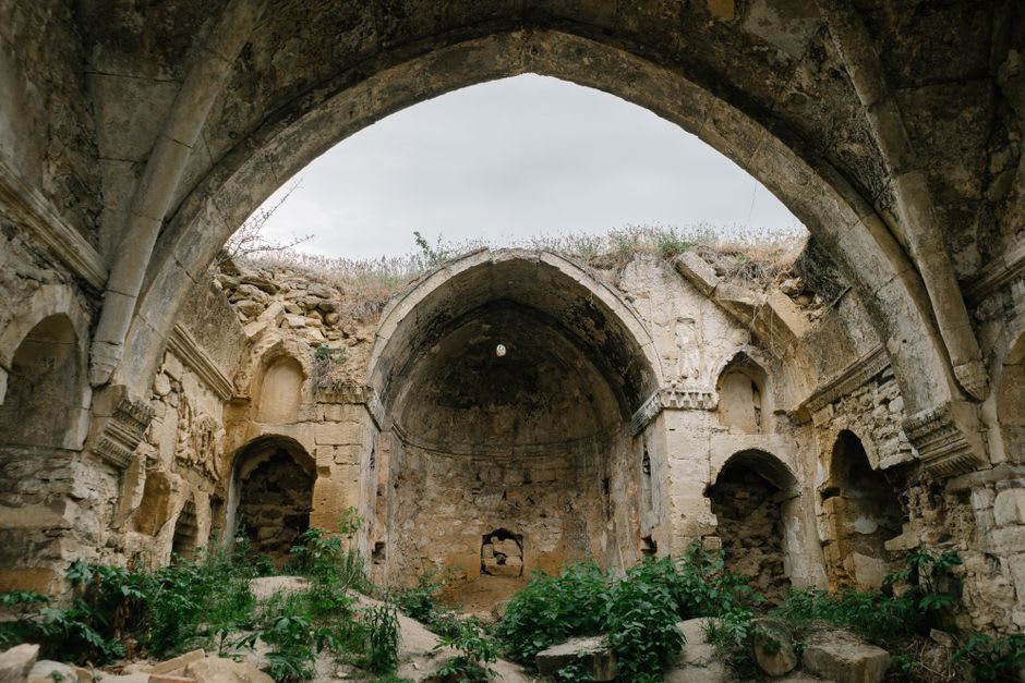 A crumbling stone archway at Eden Brown Estate with roots and vines growing through the old masonry