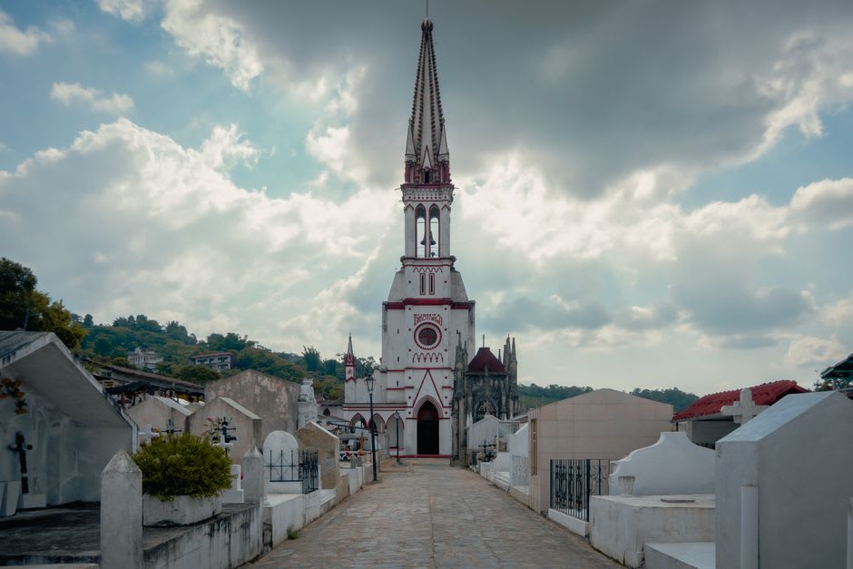 La Iglesia Anglicana de St. Thomas en Middle Island con sus paredes encaladas y un pequeño cementerio colonial