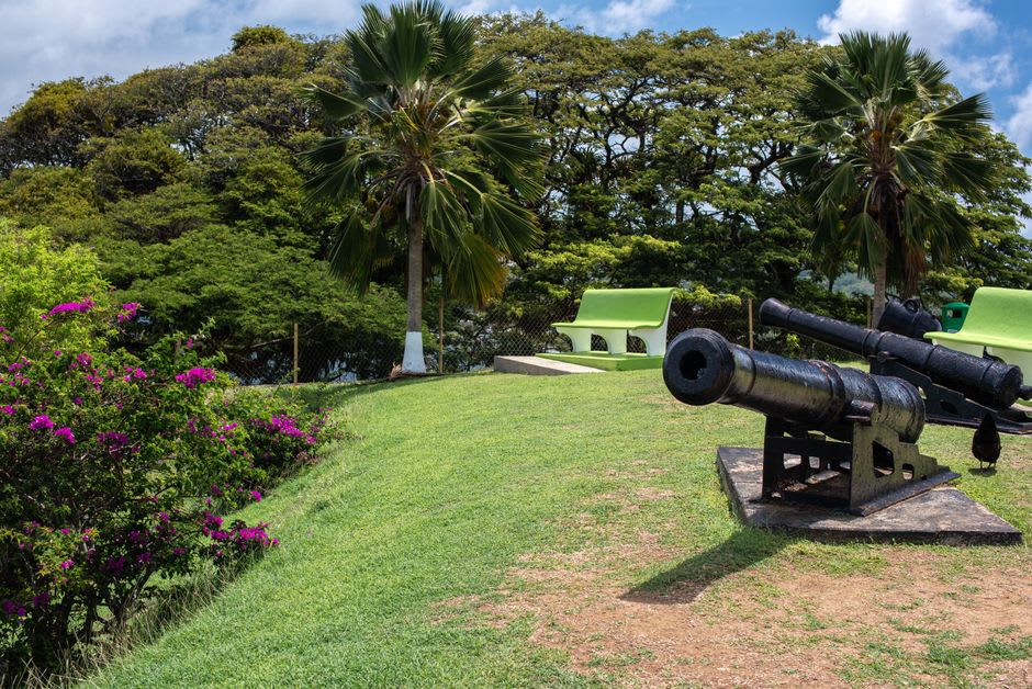 Cannon lined up along the stone ramparts of Fort Louis facing the sea