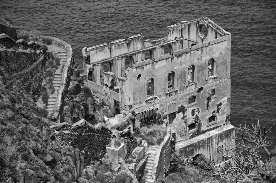 Weathered ruins of the 1950s airstrip on Ile Tintamarre surrounded by dry coastal scrub