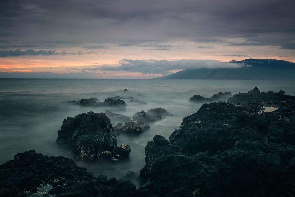 La côte occidentale accidentée de Falealupo au coucher du soleil, des vagues se brisant contre la roche volcanique noire