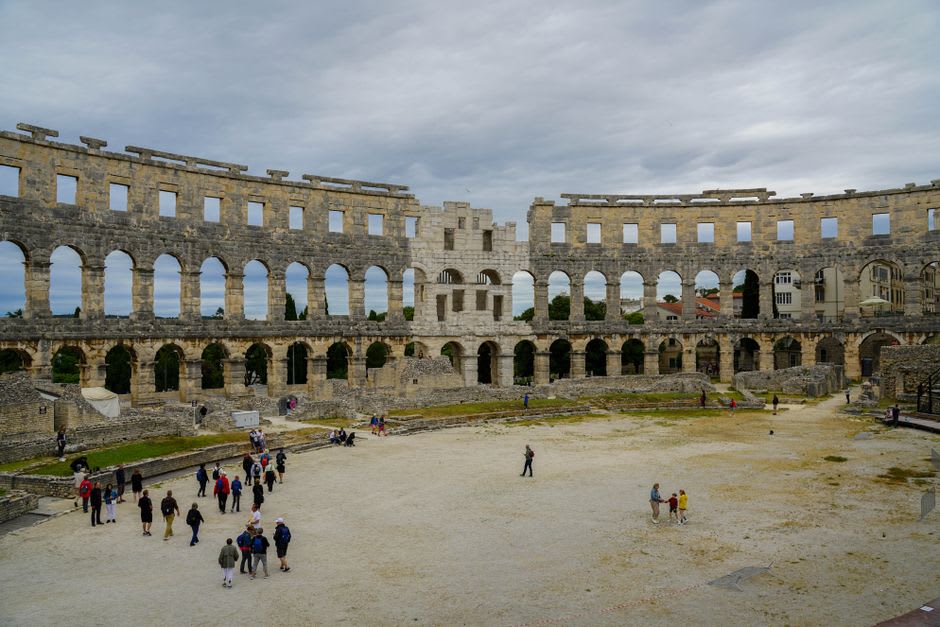 Fragmentos de suelo de mosaico geométrico en blanco y negro expuestos al aire libre entre las ruinas de Nora