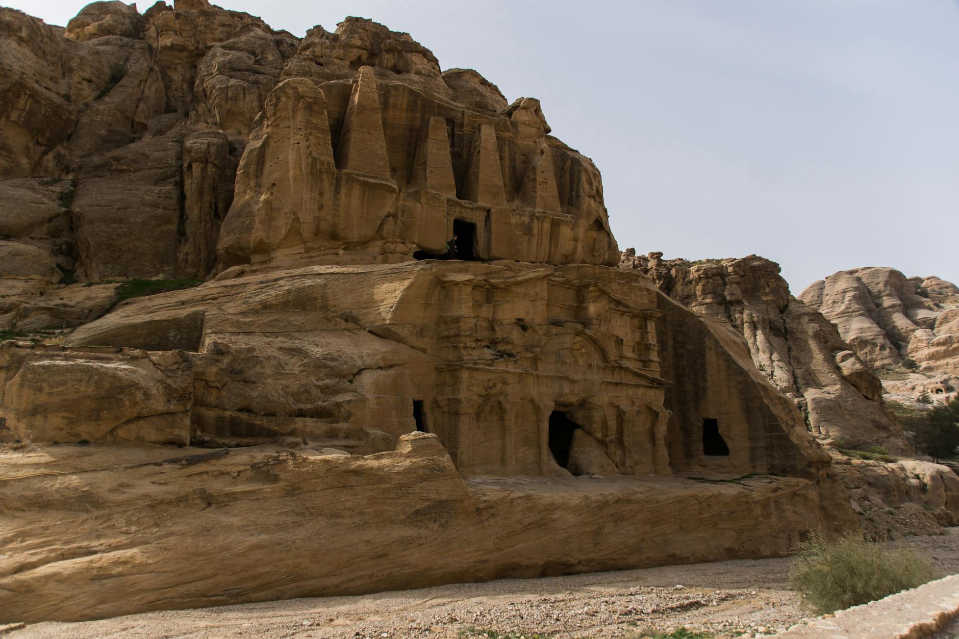 Carved Nabataean tomb facade in sandstone desert landscape