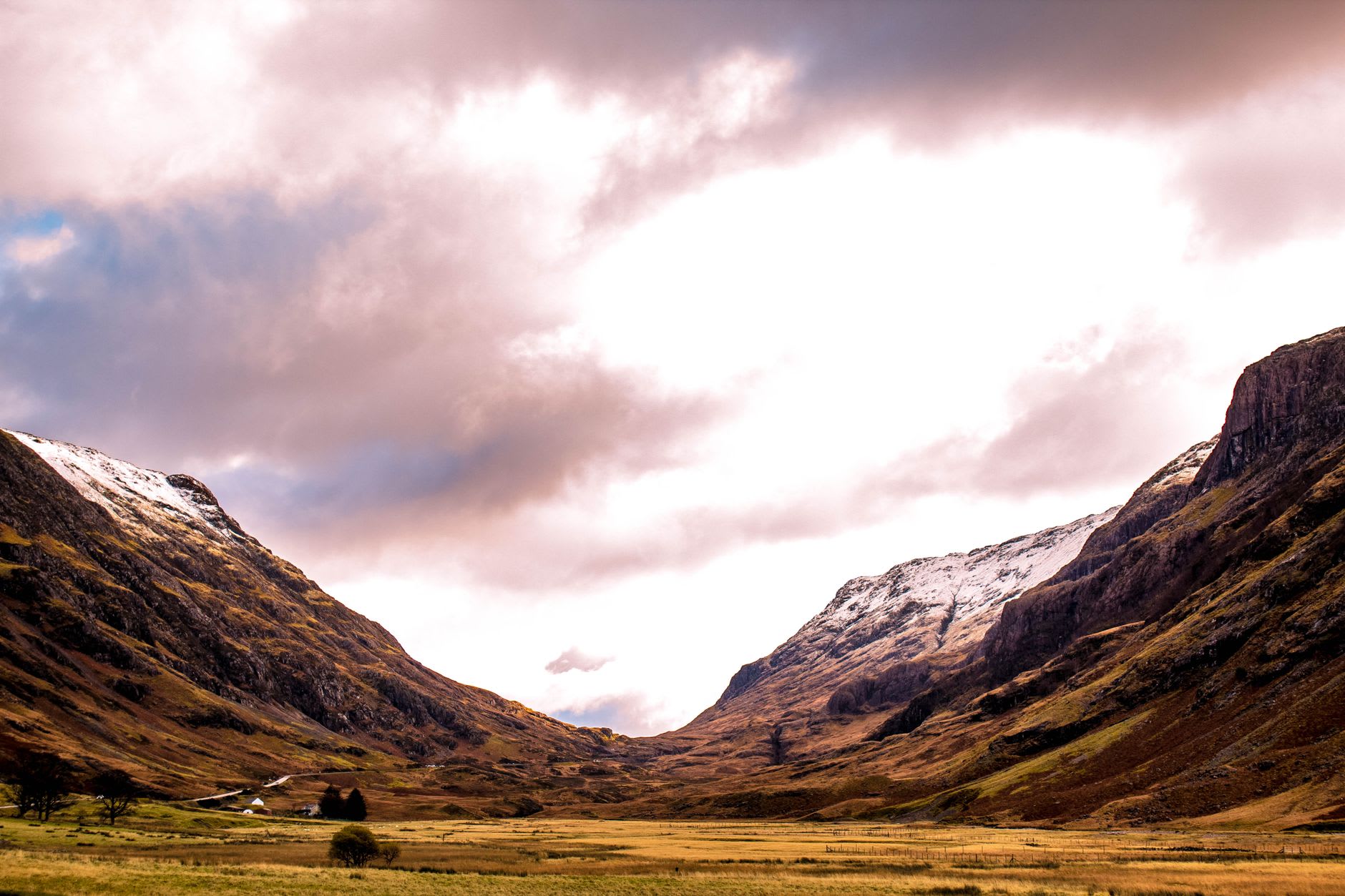Las Tres Hermanas de Glencoe elevándose sobre el fondo del valle, sus oscuras crestas bordeadas de nieve bajo un cielo gris acero invernal