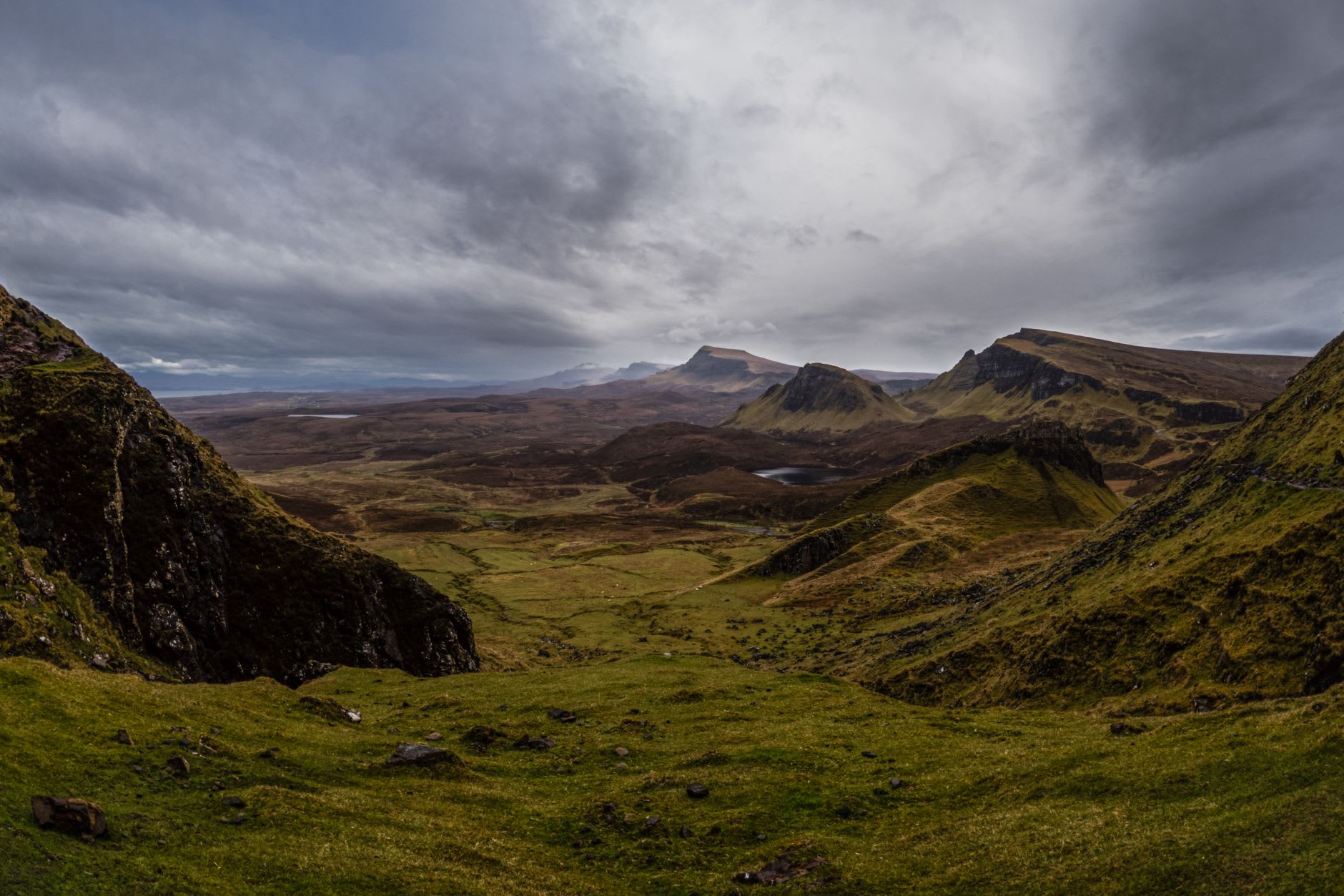 The Quiraing on Trotternish peninsula, tilted rock tables emerging from morning mist, raven-black against pale grey sky