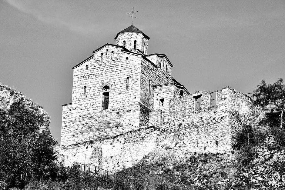 Exterior defensive stone wall and corner tower surrounding the Holy Trinity Church at Hrastovlje