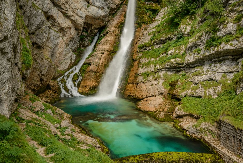 La chute en deux paliers de Savica se jetant dans un bassin turquoise en contrebas, vue depuis la plateforme en bois