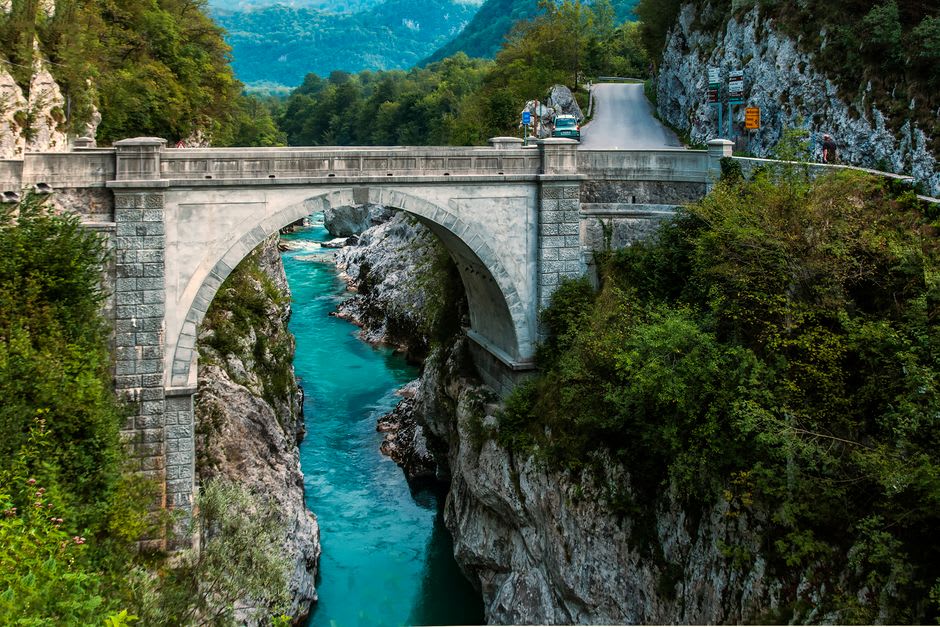 The single stone arch of Solkan Bridge spanning the turquoise Soča River with a train crossing near Nova Gorica