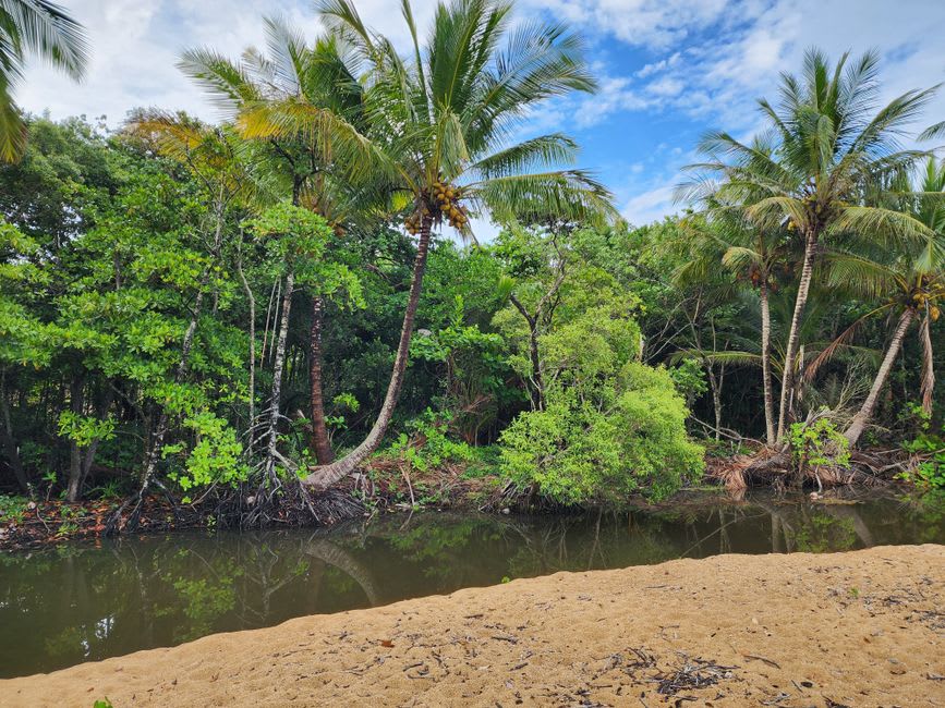 Narrow lagoon channel with mangrove edges leading toward the sacred islet near Munda