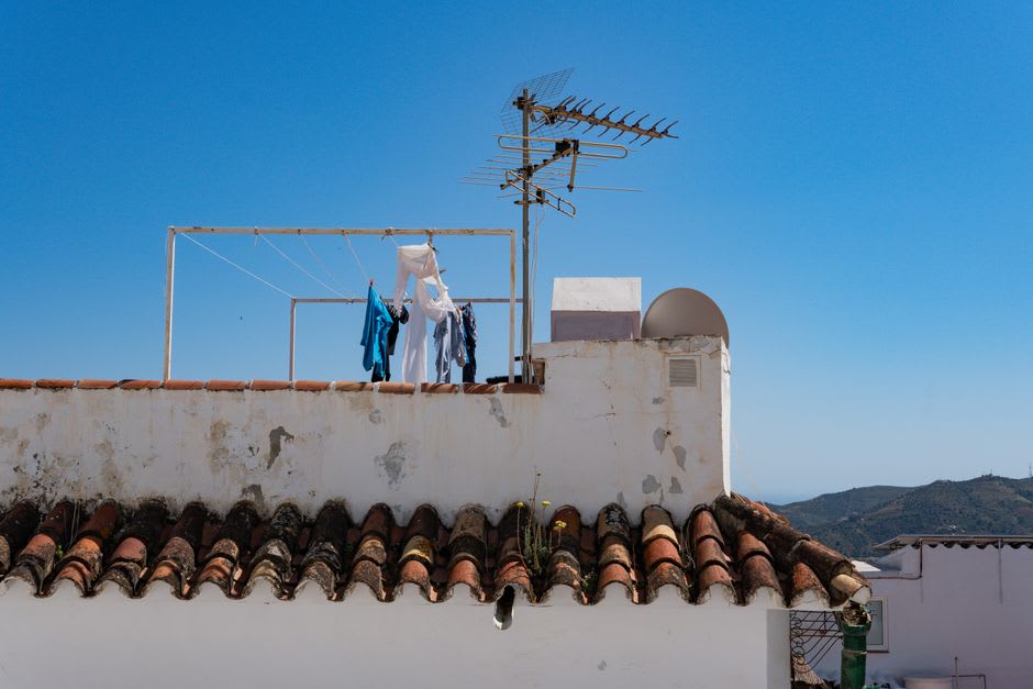 View over Frigiliana's terracotta rooftops toward the Sierra de Almijara mountains at golden hour