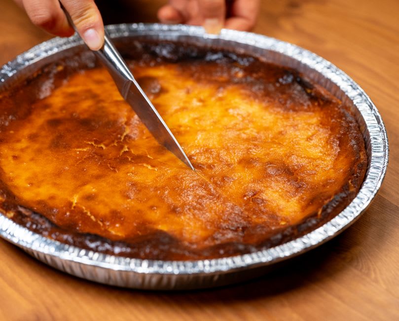 Traditional Cantabrian quesada pasiega cheesecake displayed in a bakery window in Santillana del Mar
