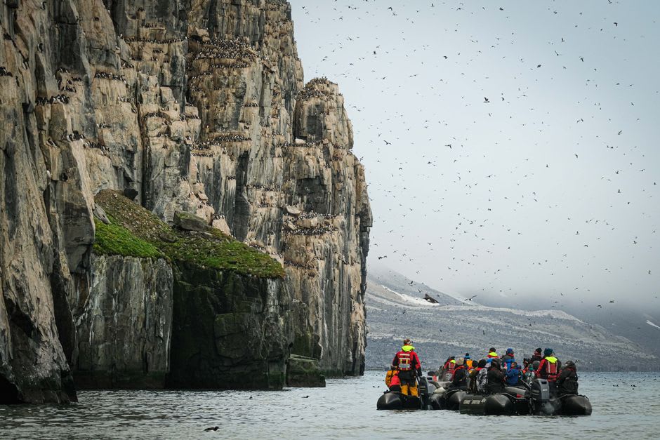 The Zodiac drifting slowly along the base of Alkefjellet's dark basalt columns
