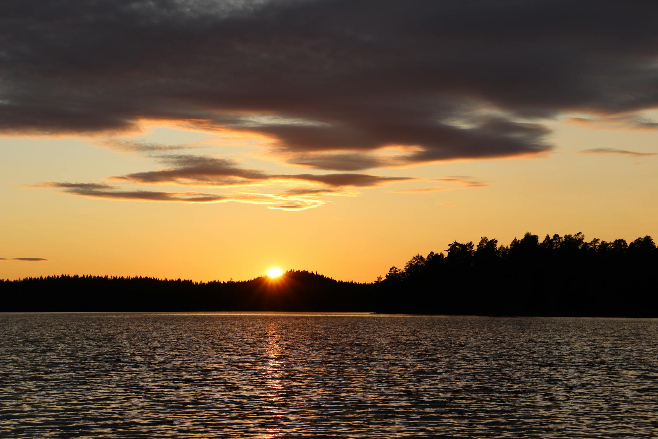 Serene lake sunset in Sweden with golden sky reflections