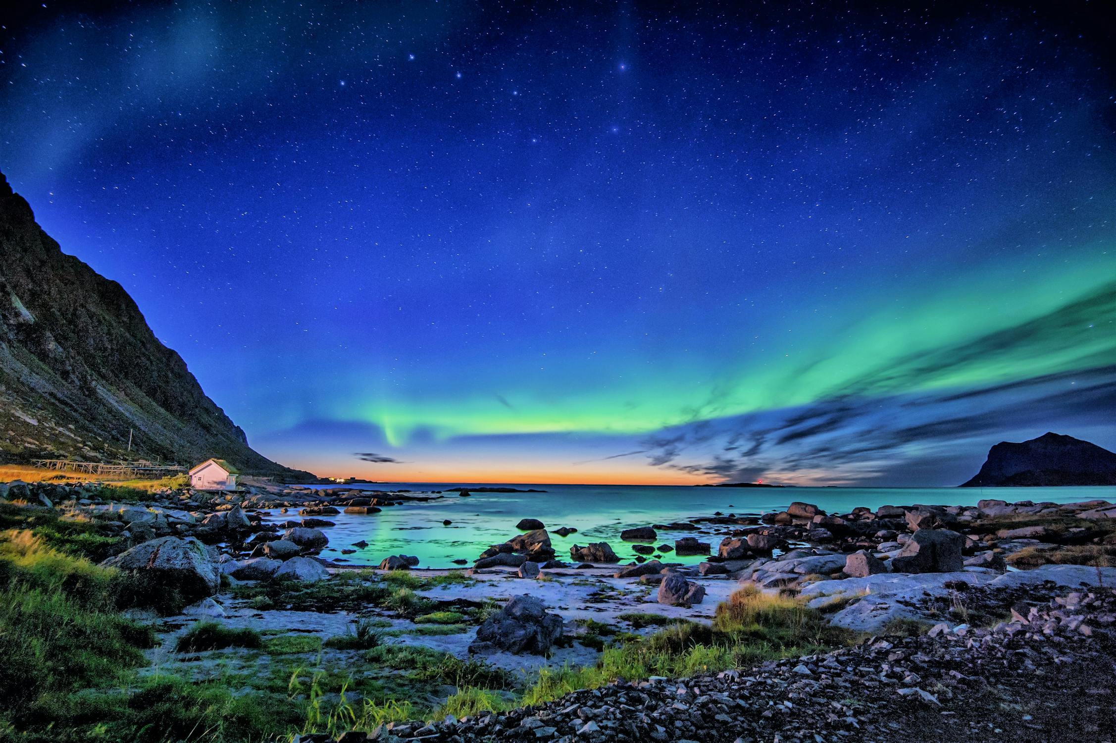 Aurora borealis illuminating a coastal Arctic landscape