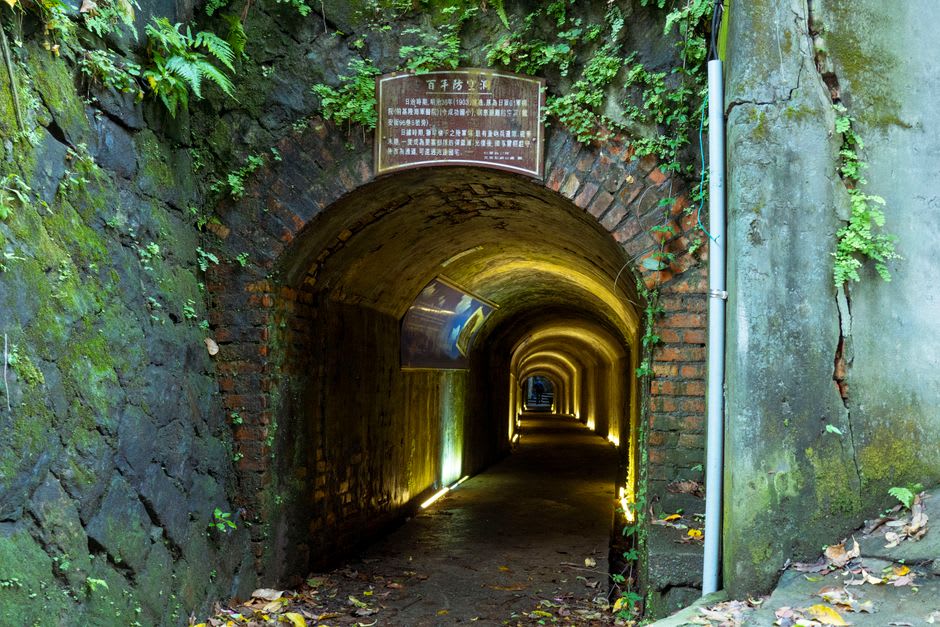 Interior view of the H-shaped Beihai Tunnel showing granite walls and a stone docking ledge exposed at low tide, Nangan, Matsu