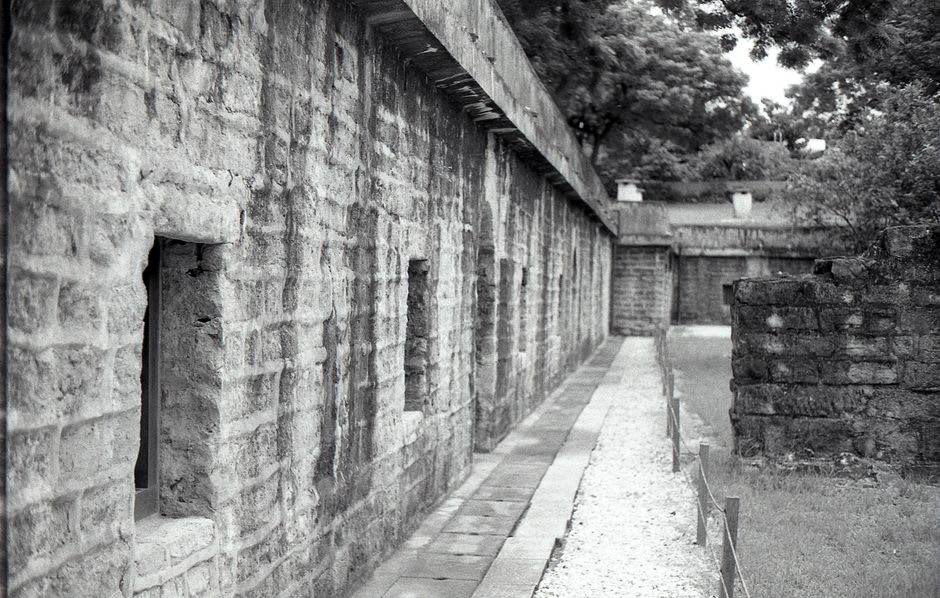 Ruines criblées de balles et sans toit de la vieille maison occidentale de Beishan à Kinmen, avec la lumière du soleil traversant les cadres de fenêtres vides