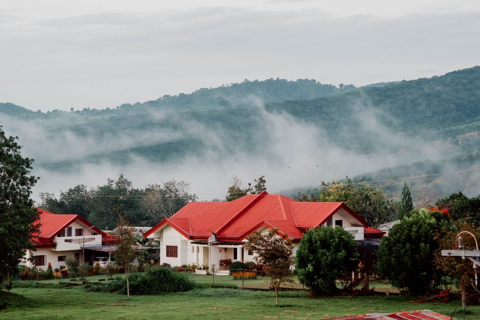 A cluster of European-style chalet guesthouses on a hillside near Cingjing, wrapped in evening mist