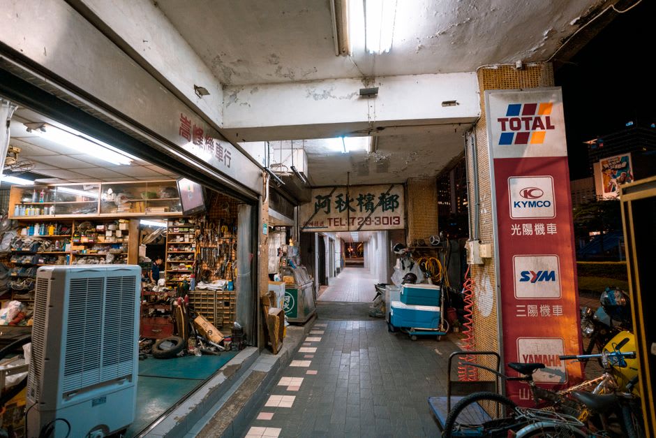 Interior de la galería comercial techada de Fengyuan bordeada de pequeñas tiendas locales e iluminación tenue en el techo