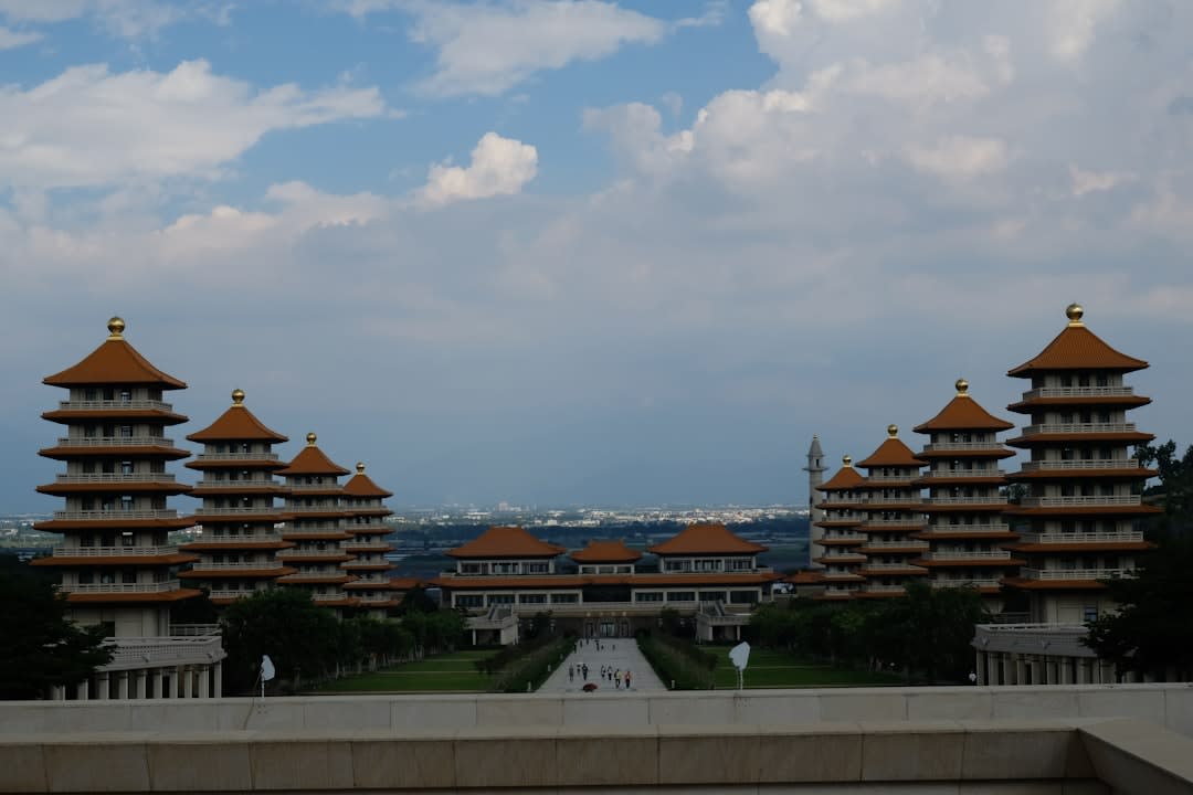 Rows of golden Buddha statues lining the plaza approach toward the towering seated Buddha at Fo Guang Shan