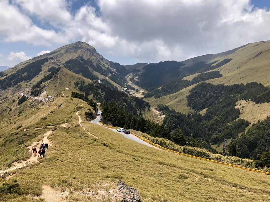 Hikers walking the exposed ridge trail toward the summit of Hehuanshan
