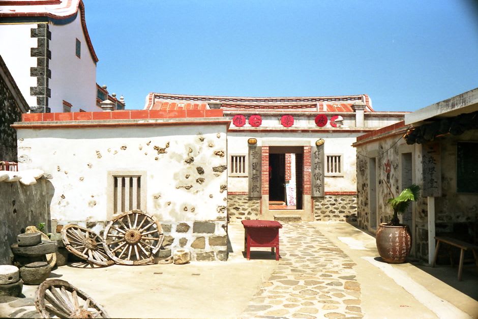 Puerta de ciudad de piedra desgastada del Casco Antiguo de Hengchun con raíces de banyan creciendo dentro del muro circundante