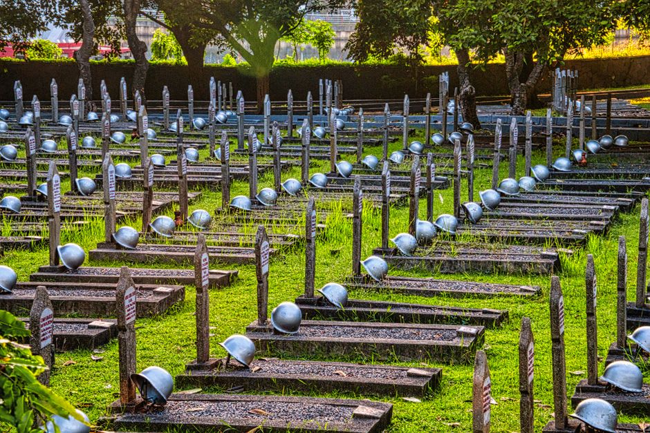 Stone memorial markers at the site of the former Jinguashi prisoner-of-war camp, surrounded by greenery