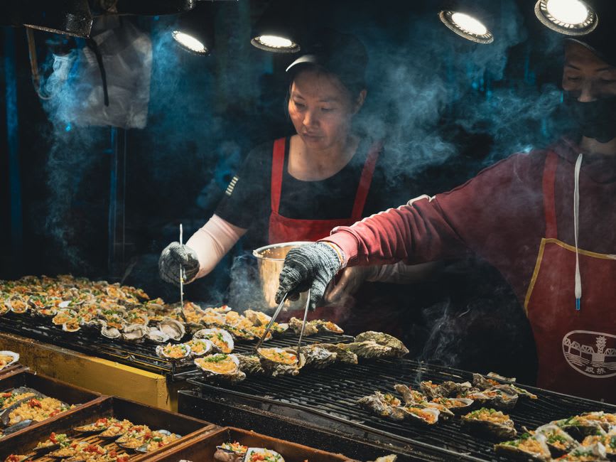 Les échoppes du marché de nuit de Miaokou luisant sous des lanternes rouges près du temple Dianji, des vendeurs préparant des plats de fruits de mer