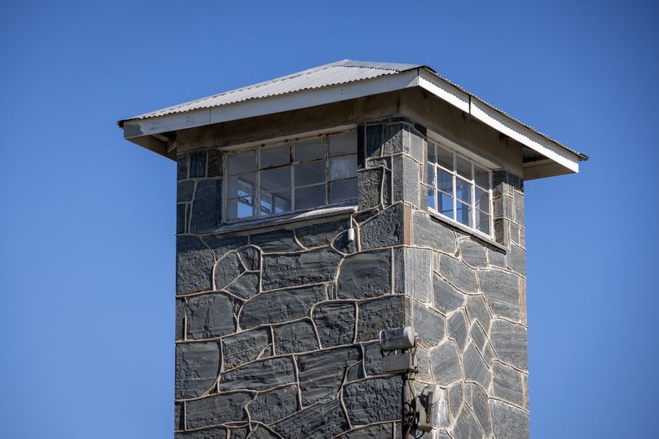 La Torre Deyue, una alta torre de vigilancia de piedra con estrechas ventanas de tronera, elevándose sobre los techos de la Aldea Shuitou