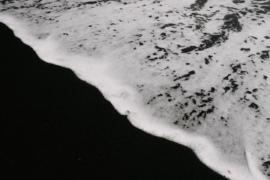 Playa de arena volcánica oscura en Da'an, en la costa sur de la Isla Qimei, con dunas bajas y orilla vacía