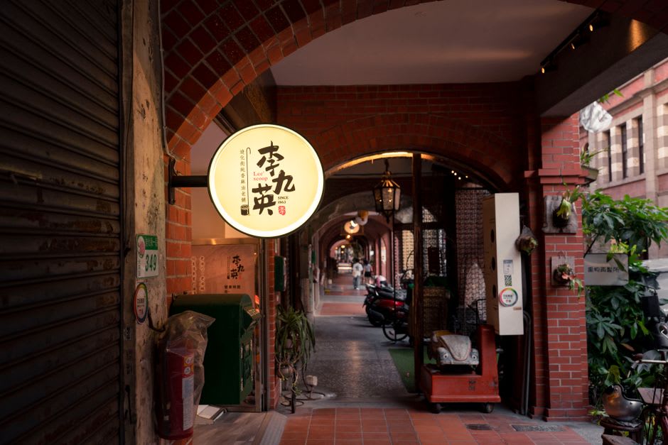 The covered brick arcade of Sanxia Old Street, each shopfront carved with a different baroque facade