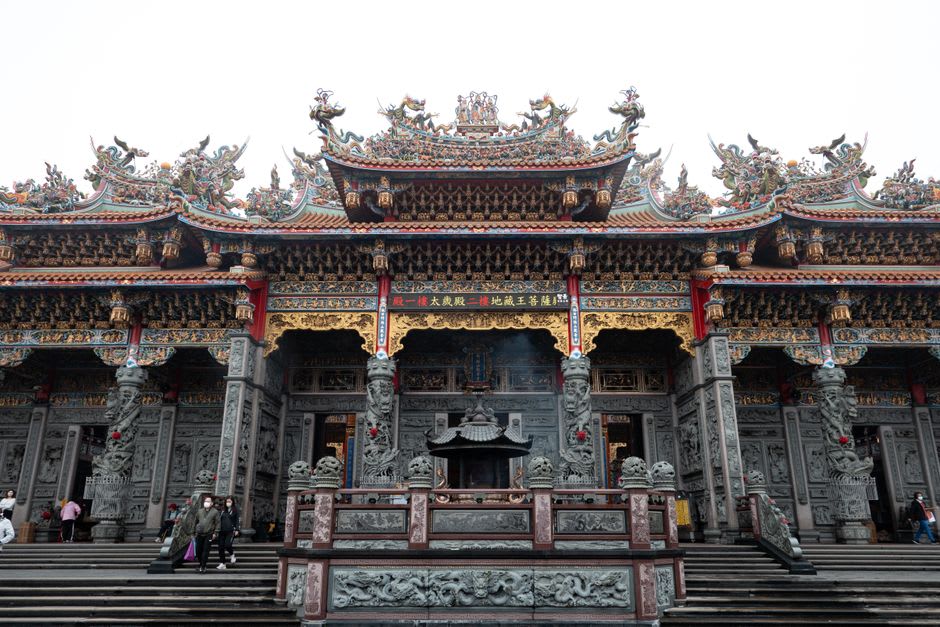 Densely carved stone pillars and dragon reliefs inside Zushi Temple in Sanxia