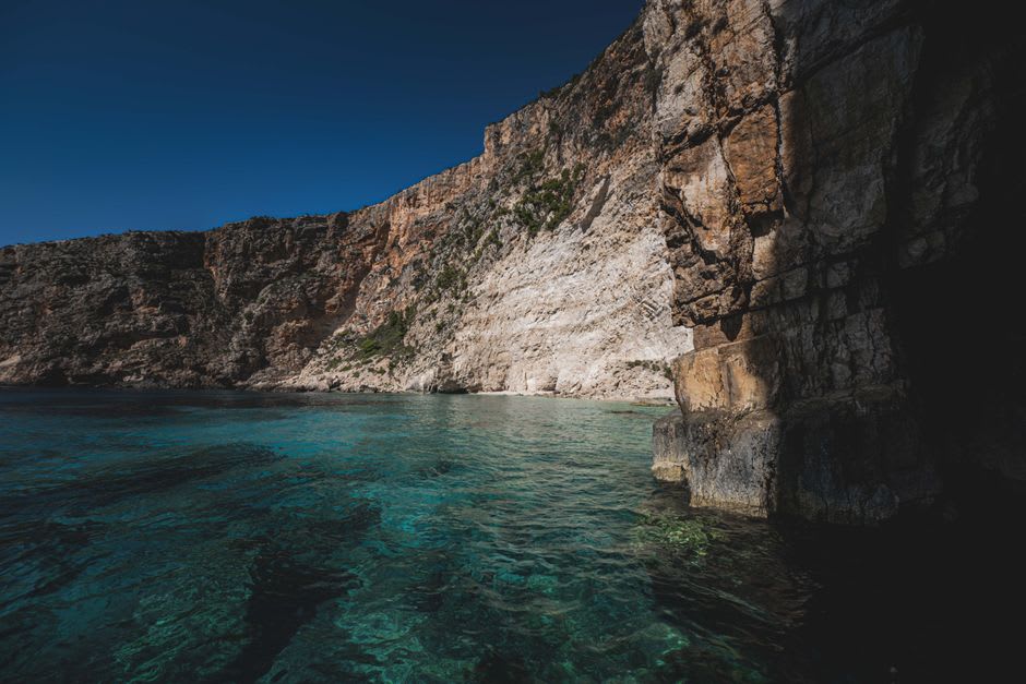Los acantilados costeros escarpados y el agua turquesa de la Isla Orquídea vistos desde un camino de scooter