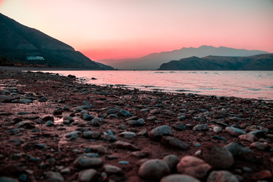 The pebble beach and mountain backdrop at Qixingtan seen from an elevated viewpoint at sunset