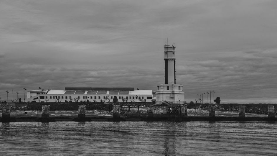 El Faro de Wuqi pintado en blanco y negro estilo tablero de ajedrez contra un cielo costero gris