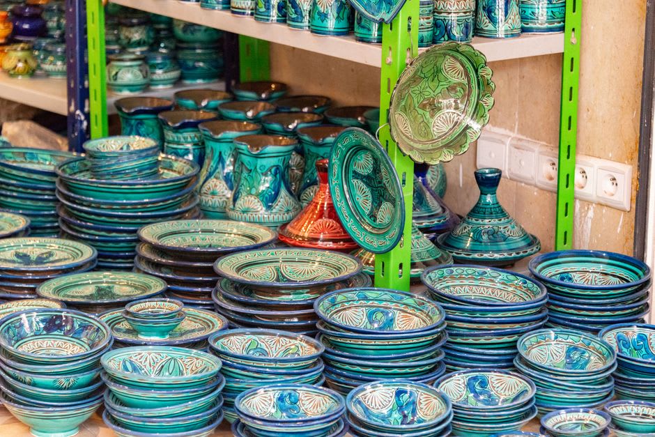 Shelves of glazed ceramic bowls and tea sets displayed outside a pottery shop on Yingge Old Street