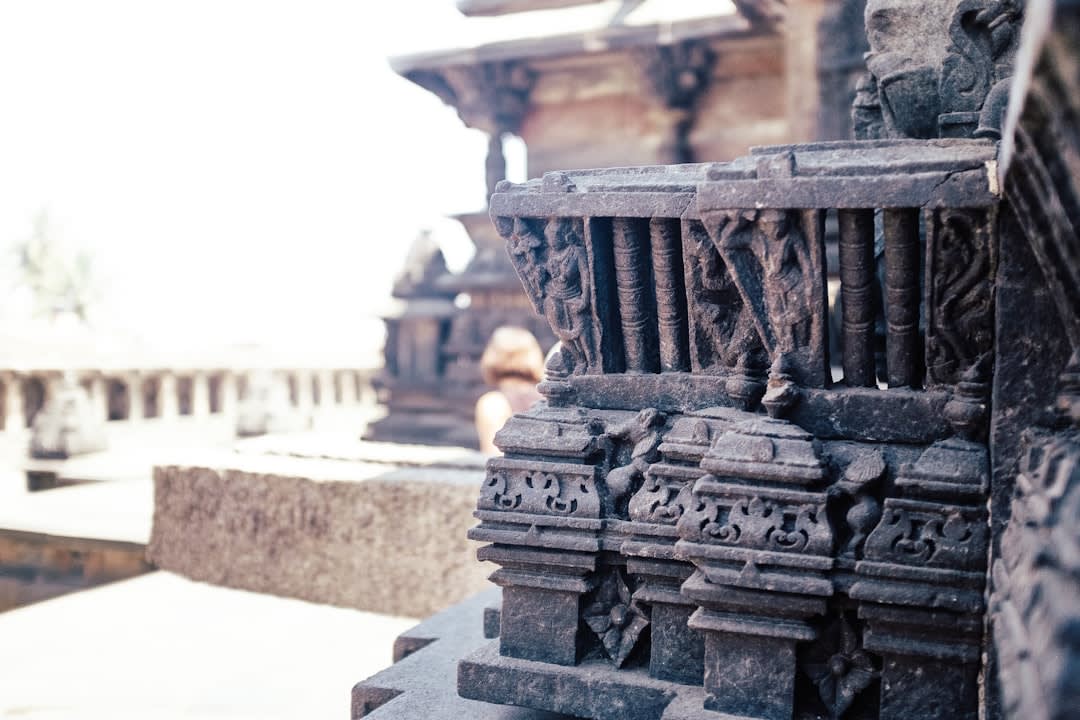 Carved stone details on the temple base, weathered by centuries of Tamil Nadu weather
