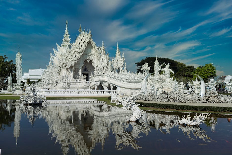 Ornate blue temple interior with white Buddha statue in Chiang Rai